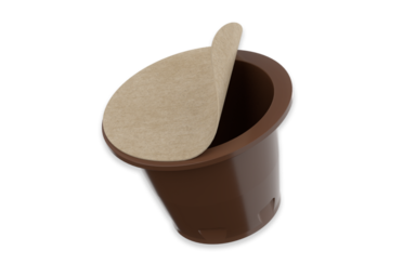 Darstellung der NAT®Cap Home mit geöffneter, heimkompostierbarer Oberfolie. Das Bild zeigt den biobasierten Kapselkörper aus braunem Material und die natürliche, faserbasierte Siegelfolie – beide vollständig heimkompostierbar und lebensmittelzertifiziert. Symbol für Kreislaufdenken, Nachhaltigkeit und Funktionalität: eine Kapsel, die sich nach Gebrauch rückstandsfrei in den natürlichen Stoffkreislauf eingliedert.