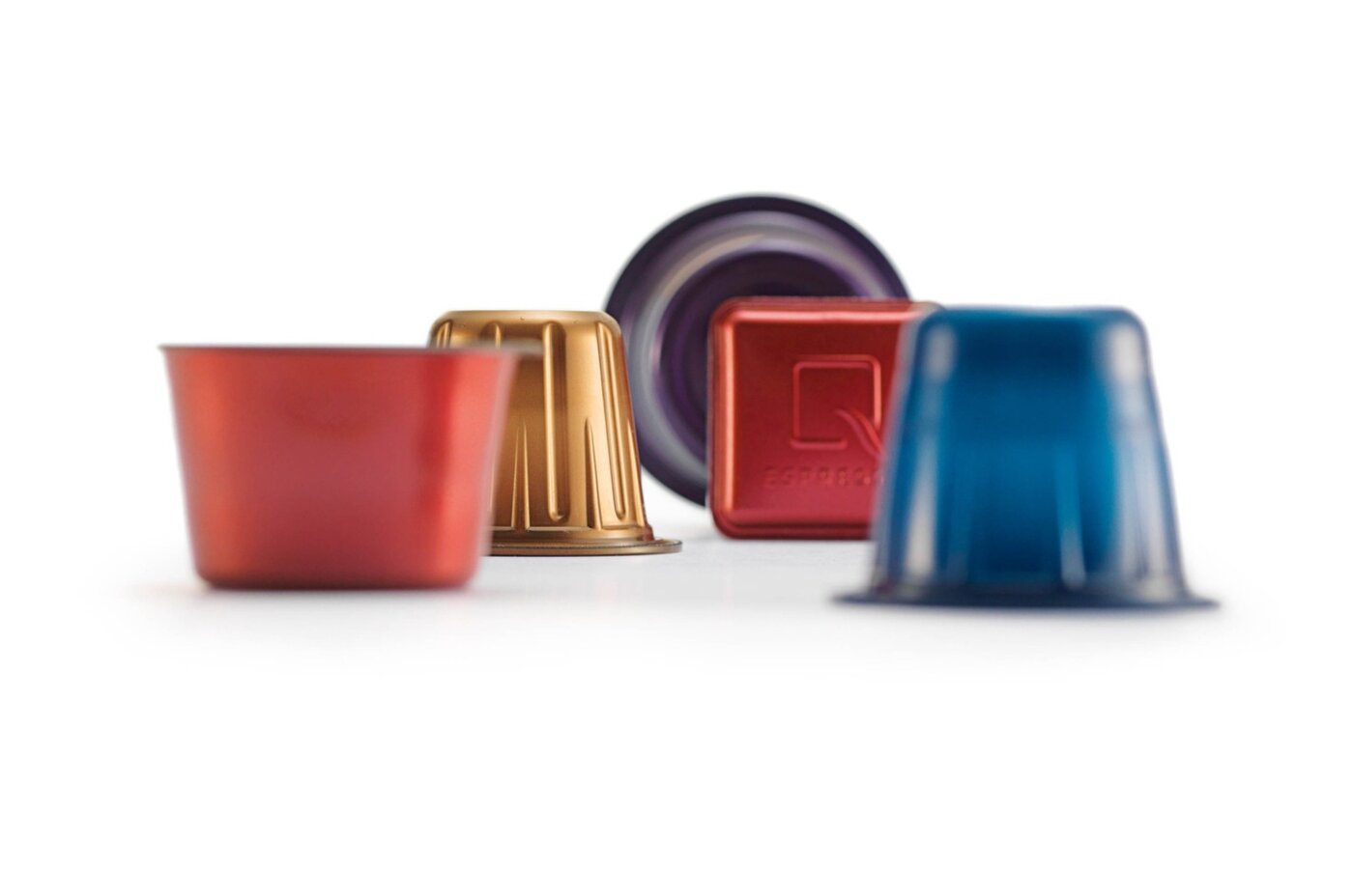 Mehrere farbige Kunststoffkapseln in unterschiedlichen Formen und Grössen – entwickelt für optimalen Aromaschutz und Kompatibilität mit gängigen Kaffeesystemen.