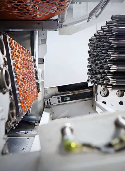 Tiefziehform mit orangefarbenen Kunststoffbechern – präzise und effiziente Thermoform-Technologie von säntis packaging.