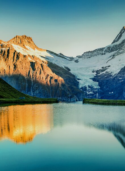 Schneebedeckte Berge spiegeln sich im klaren See – Sinnbild für starke, vertrauensvolle Partnerschaften und transparente Zusammenarbeit im Nachhaltigkeitsnetzwerk von säntis packaging.