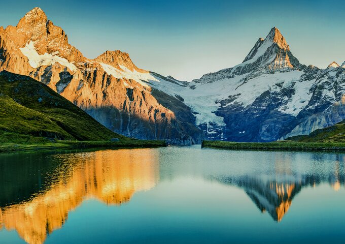 Schneebedeckte Berge spiegeln sich im klaren See – Sinnbild für starke, vertrauensvolle Partnerschaften und transparente Zusammenarbeit im Nachhaltigkeitsnetzwerk von säntis packaging.