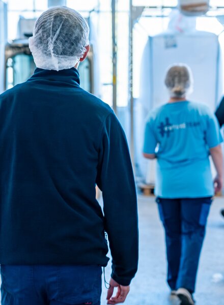 Ausbildner begleitet Lernende des #FutureTeam von säntis packaging durch die Produktionshalle – gemeinsamer Rundgang und praxisnahes Lernen im Arbeitsalltag.