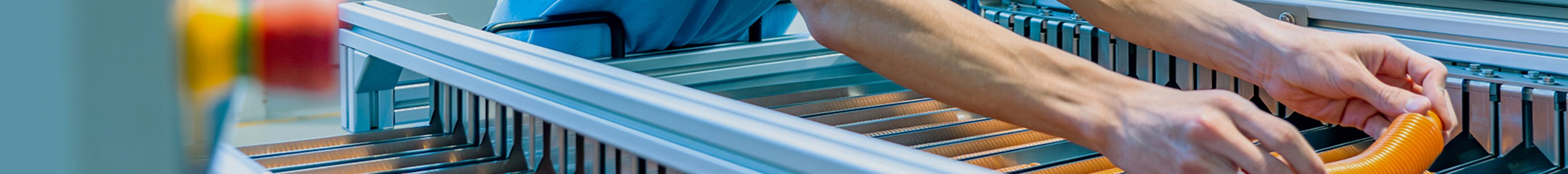 Headerbild mit Nahaufnahme eines Mitarbeitenden bei säntis packaging, der ein Kunststoffteil in eine Produktionsmaschine einlegt – Sinnbild für Präzision, Technologie und Teamarbeit im Bewerbungsprozess „Dein Weg ins Team“.