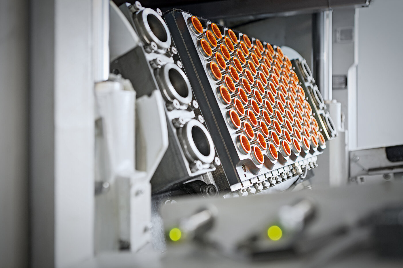 Blick in eine hochpräzise Produktionsanlage von Säntis Packaging, in der Kunststoffverpackungen mit orangefarbenen Einsätzen gefertigt werden – Sinnbild für Schweizer Qualität, Innovation und Effizienz in der Verpackungsherstellung.