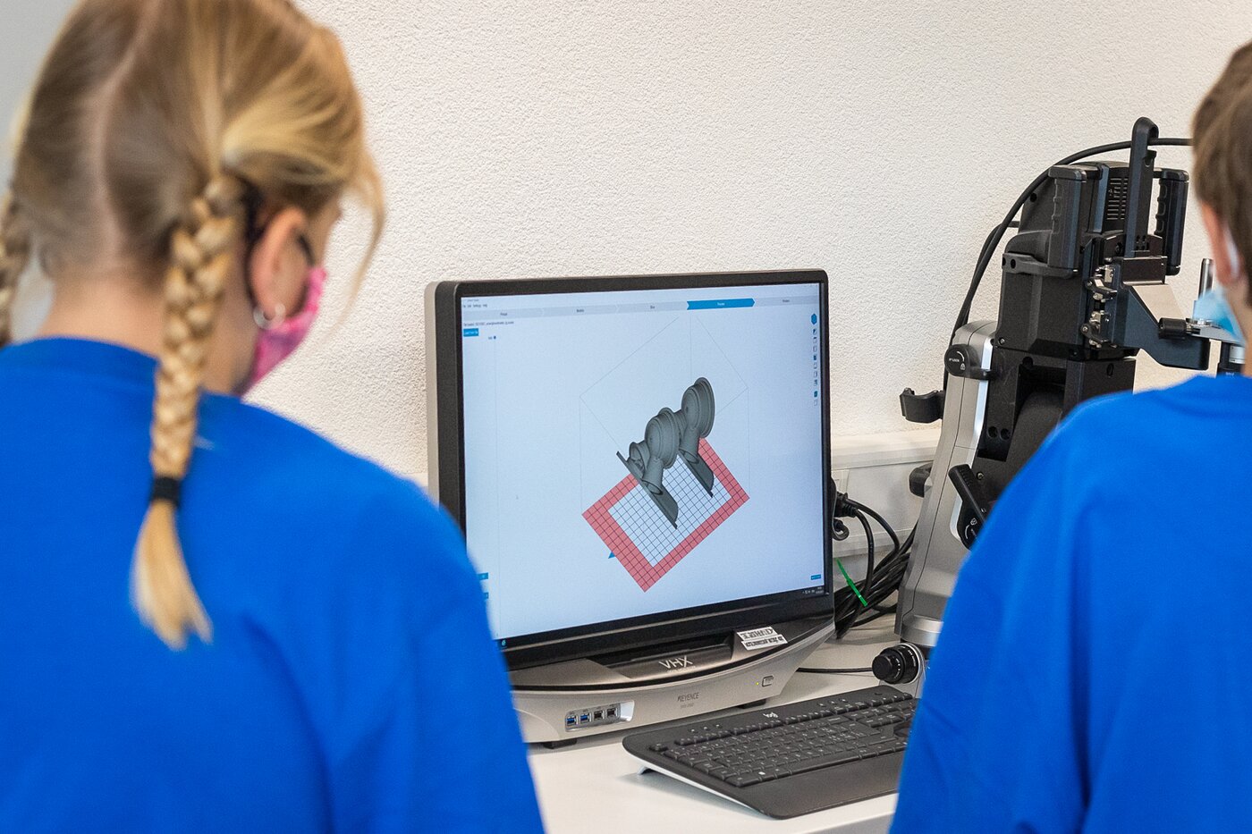 Kinder in blauen Säntis Packaging T-Shirts gestalten am Computer ein 3D-Modell im CAD-Programm während der Young-Tec-Days in Rüthi.