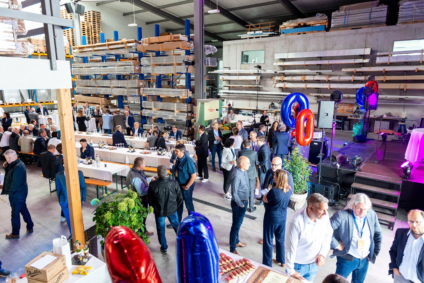 Jubiläumsfeier zum 100-jährigen Bestehen der SÄNTIS-Gruppe in Rüthi – Mitarbeitende, Partner und Gäste feiern das Firmenjubiläum in industrieller Halle mit Bühne, Festbetrieb und Austausch über die Geschichte und Zukunft des Unternehmens.