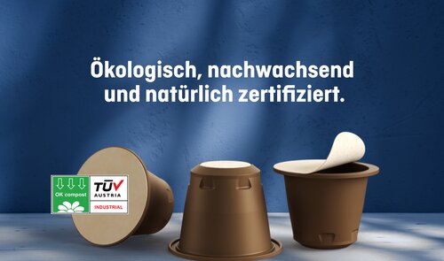 Drei braune, kompostierbare Kaffeekapseln mit TÜV-Austria- und OK-Compost-Zertifizierung, begleitet vom Schriftzug «Ökologisch, nachwachsend und natürlich zertifiziert» – Symbolbild für die nachhaltige NAT®Cap-Lösung von Säntis Packaging.